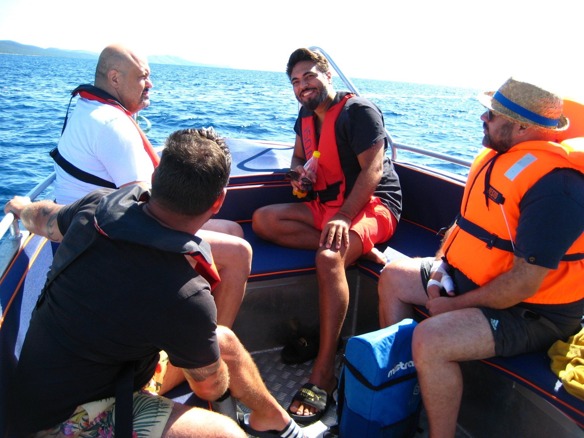 Eine Gruppe von Männern mit Schwimmwesten sitzt auf einem Boot