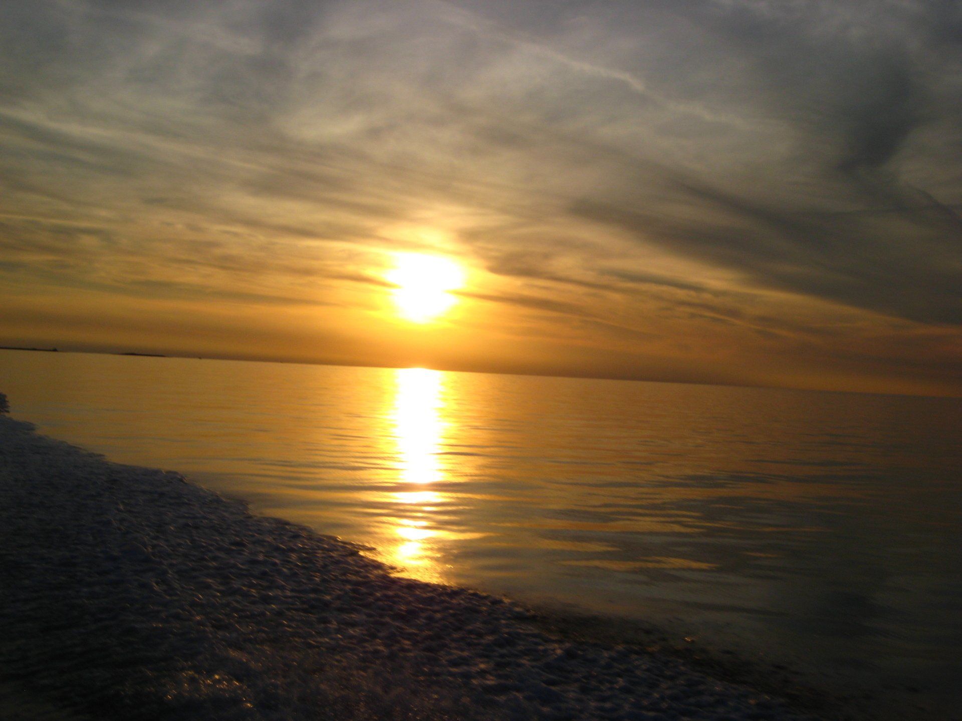 Die Sonne geht über einem Gewässer unter