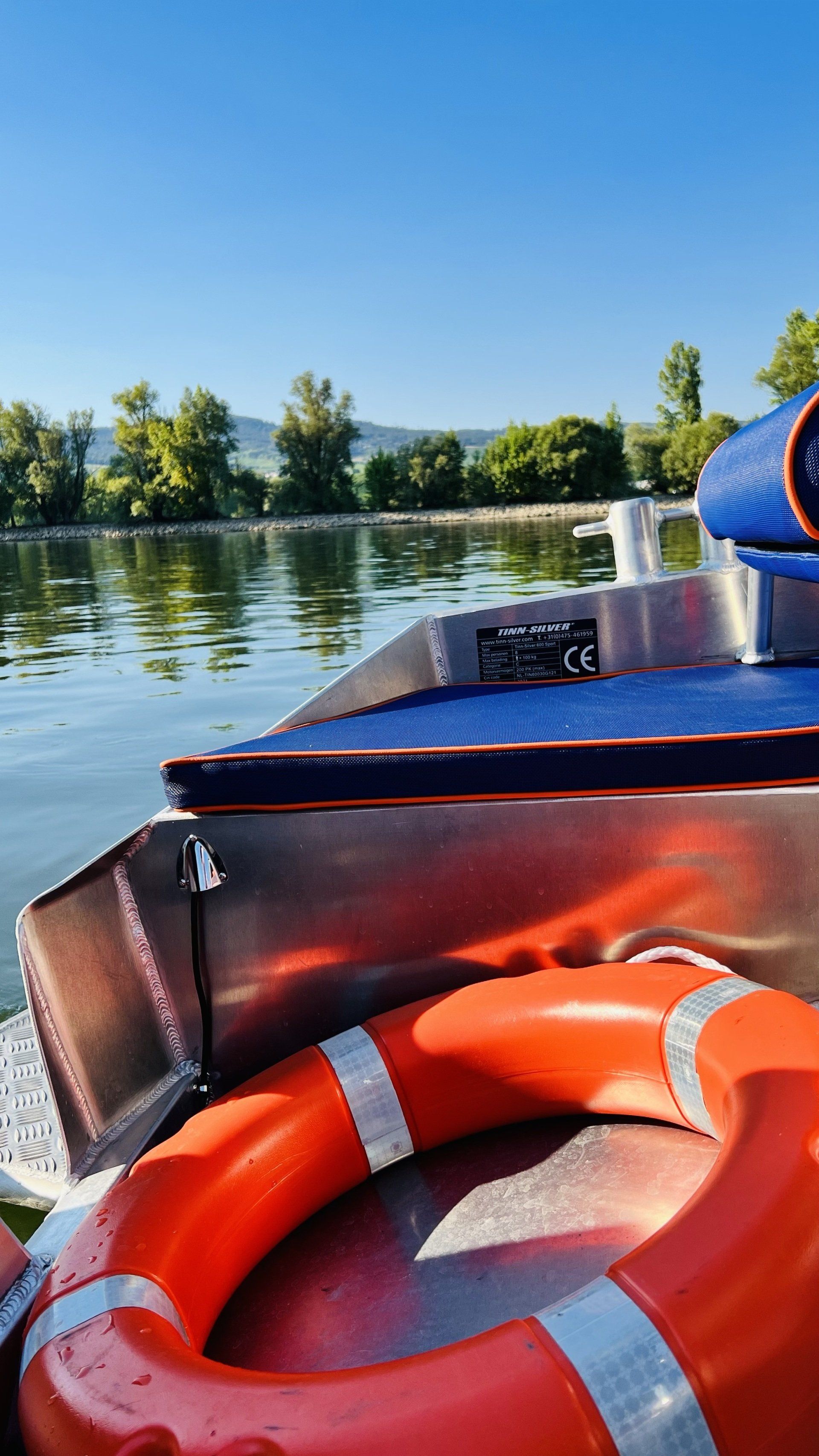 An der Seite eines Bootes befindet sich ein orangefarbener Rettungsring