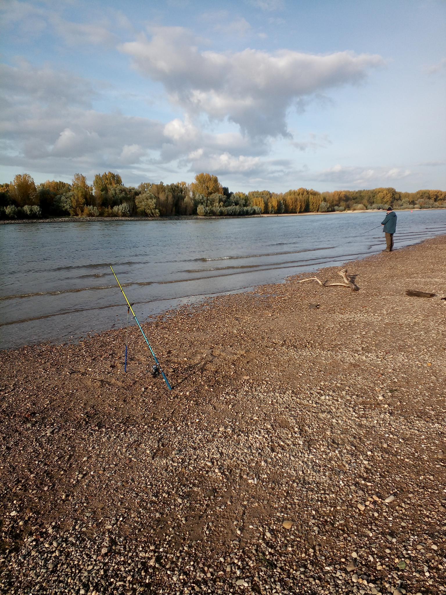 Ein Mann angelt am Ufer eines Sees