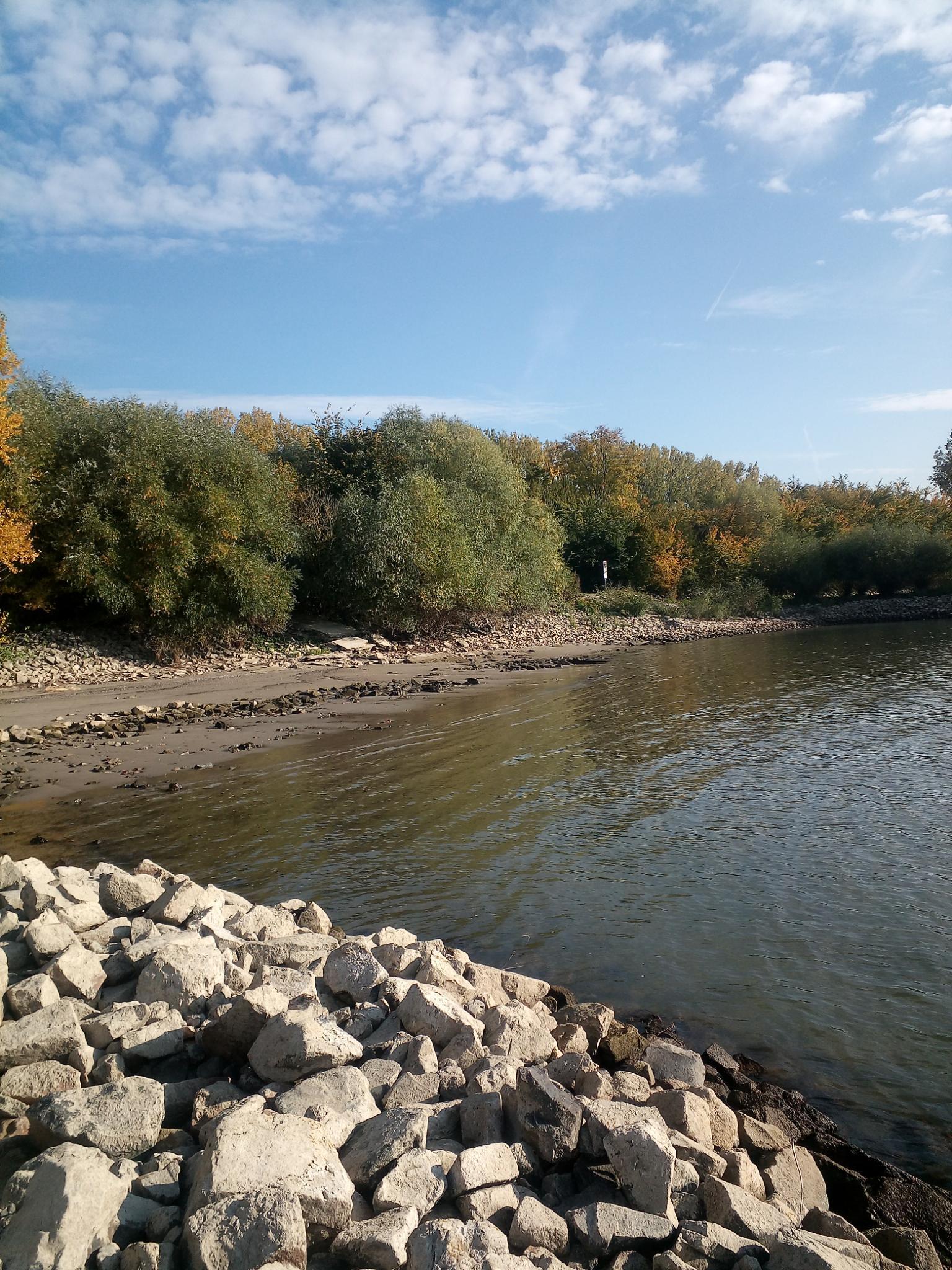Ein großes Gewässer, umgeben von Felsen und Bäumen
