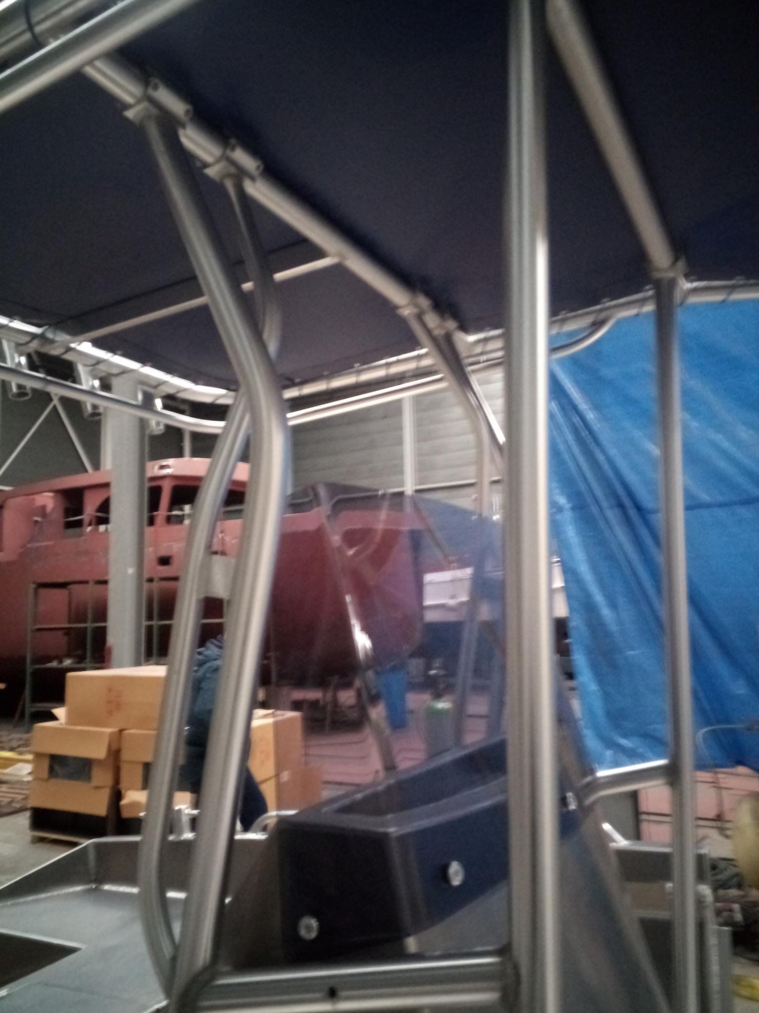 Eine blaue Plane bedeckt ein Boot in einem Lagerhaus