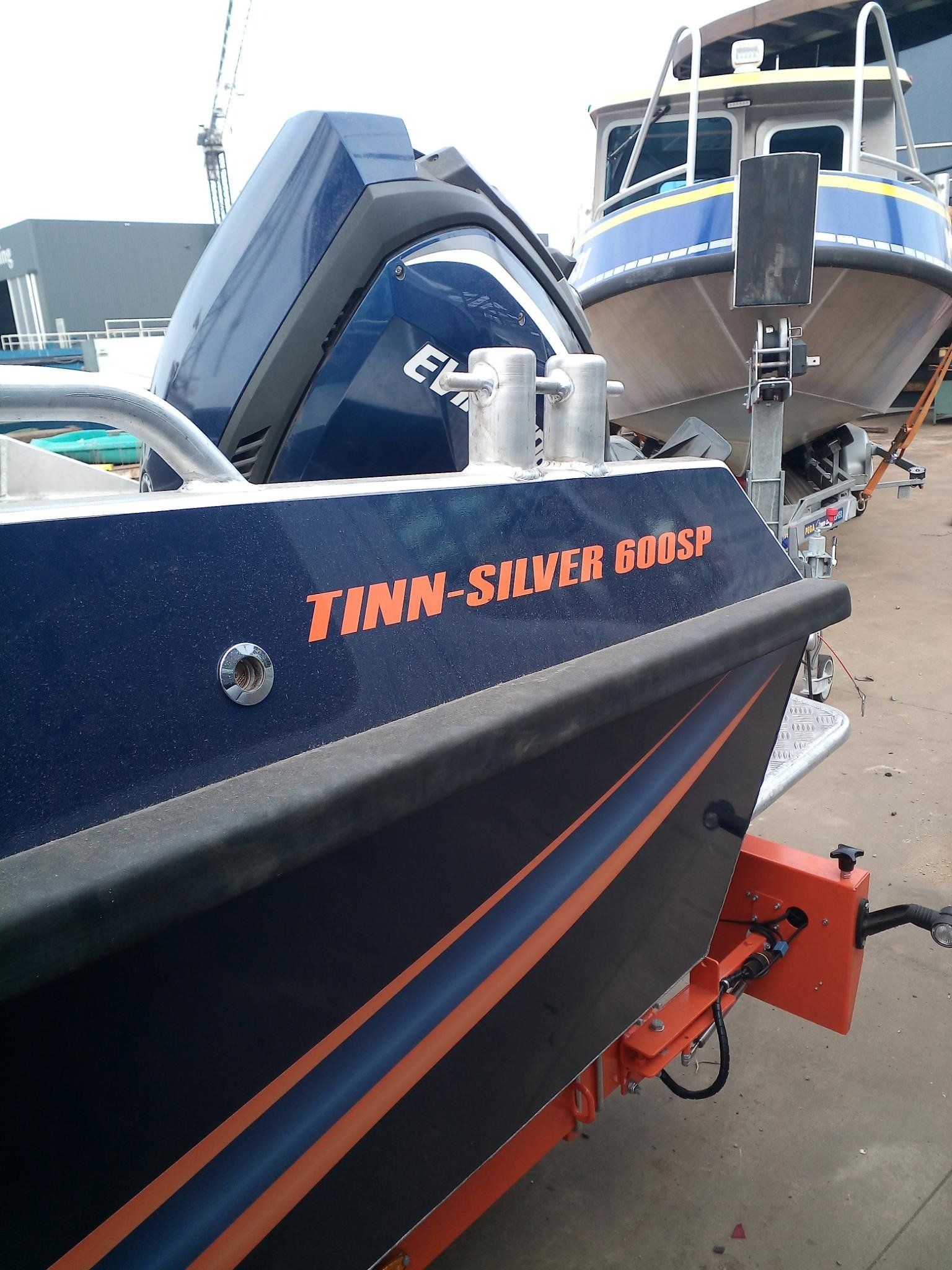 Ein blau-oranges Boot mit dem Namen Timn-Silver Goose an der Seite