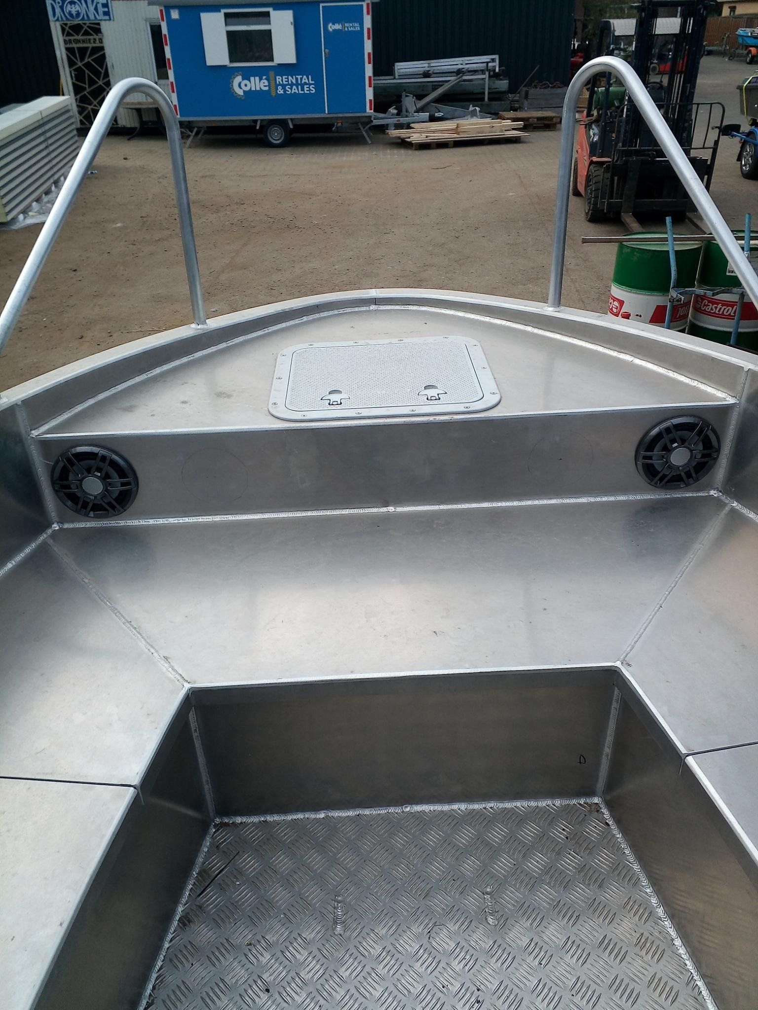 Ein Edelstahlboot steht auf einem Parkplatz