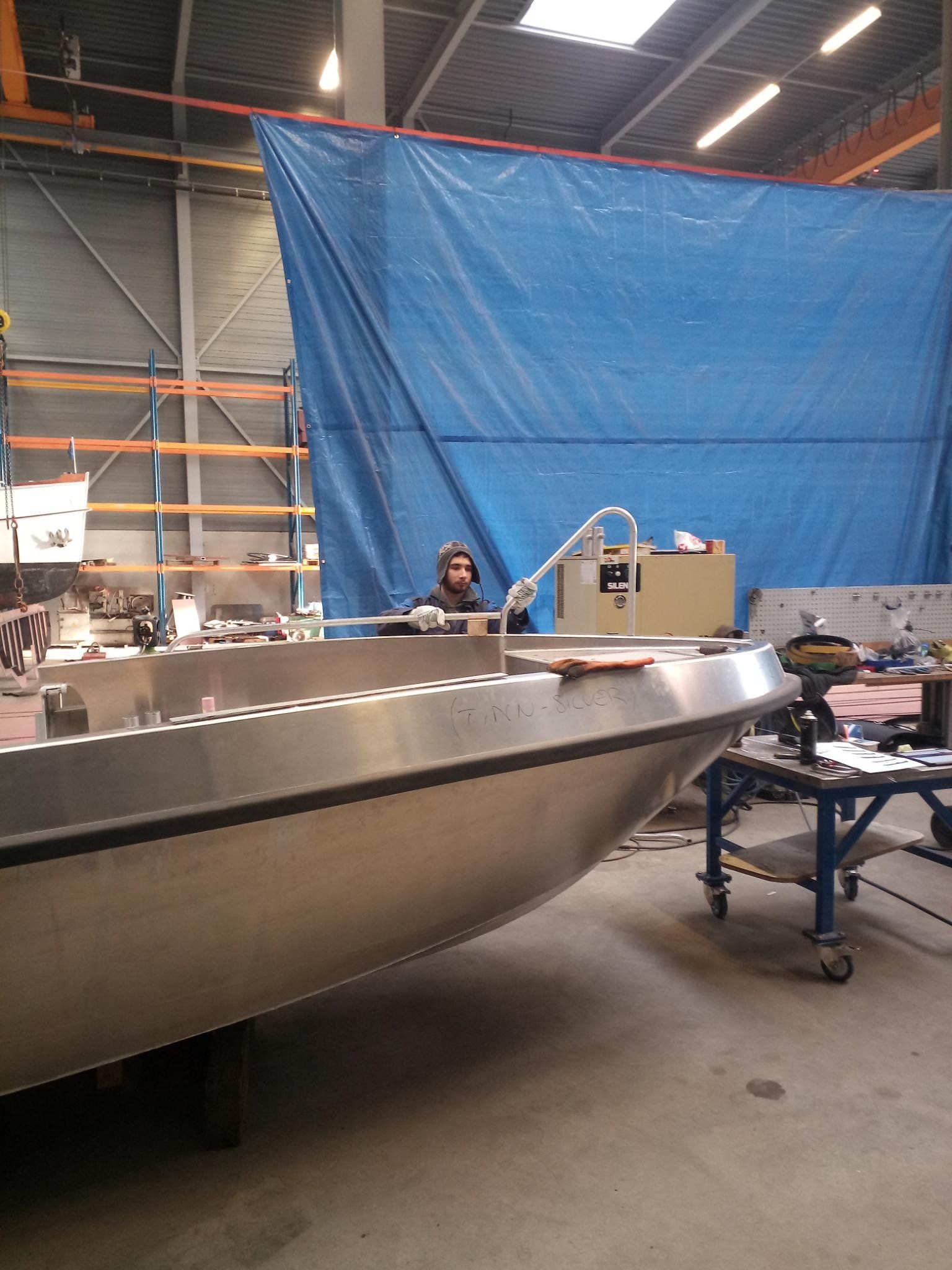 In einer Lagerhalle wird ein großes Aluminiumboot gebaut