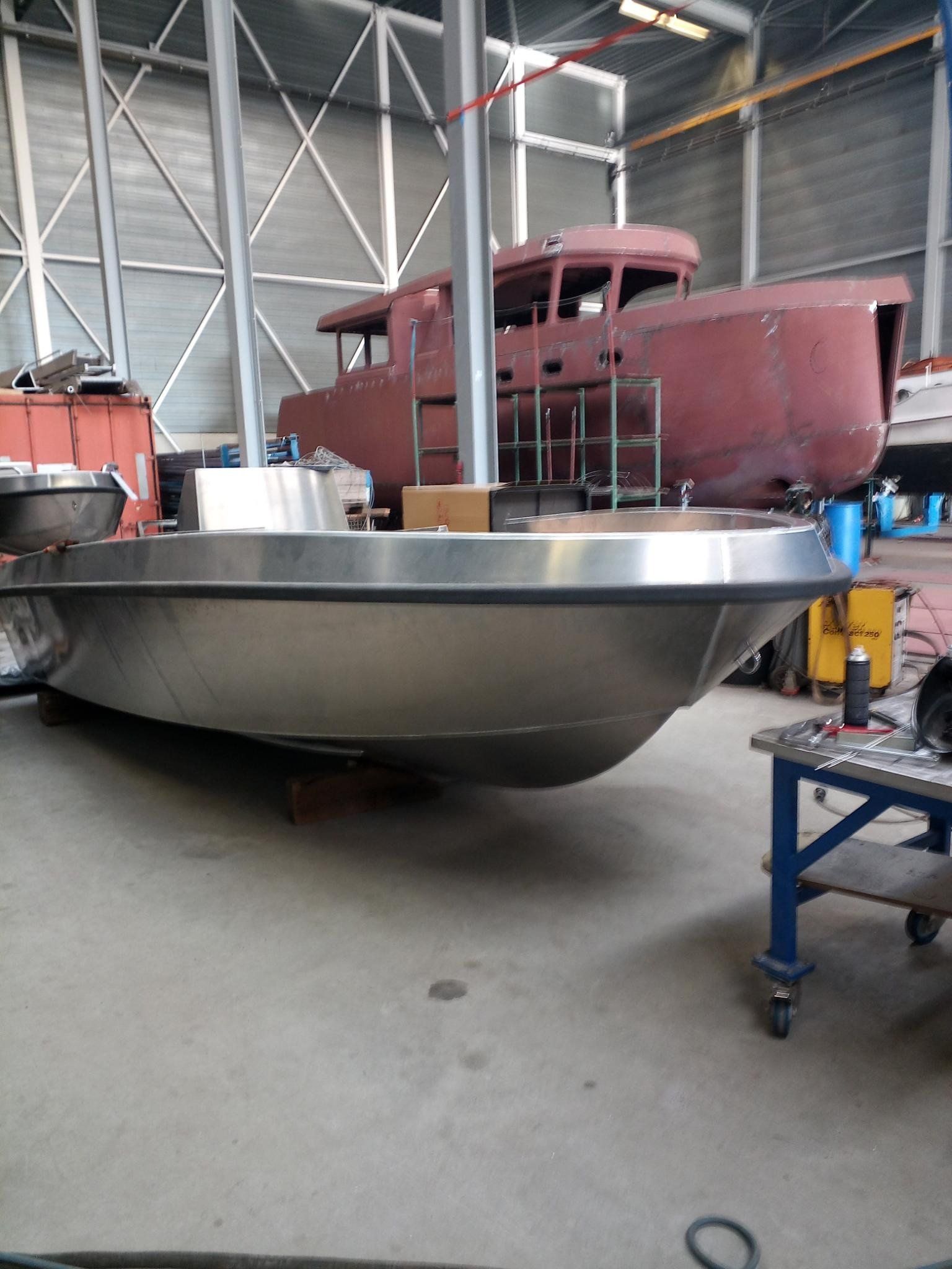 Ein großes Edelstahlboot liegt in einer Lagerhalle