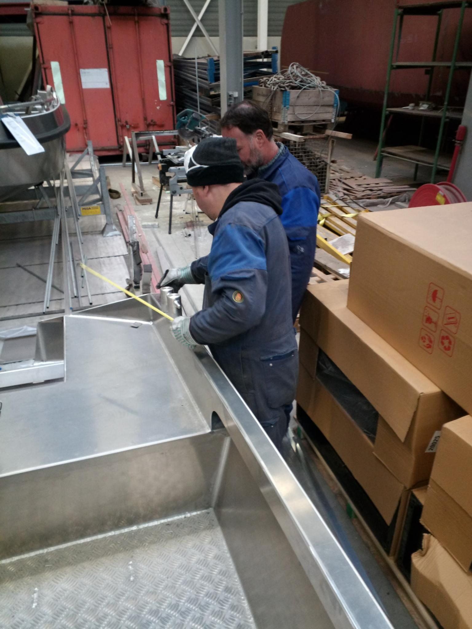 Zwei Männer arbeiten in einer Fabrik auf einem Boot