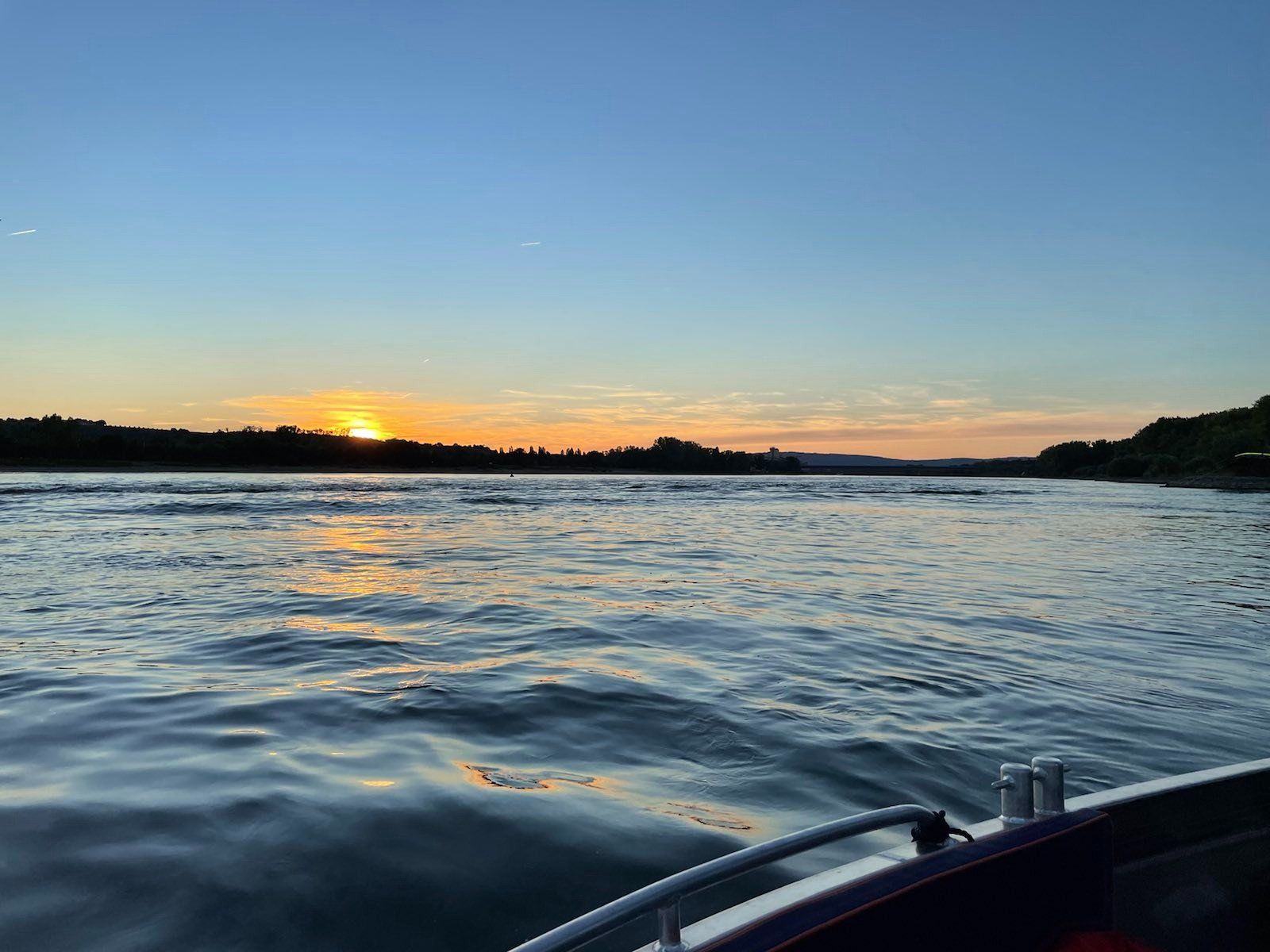 Die Sonne geht über einem Gewässer unter