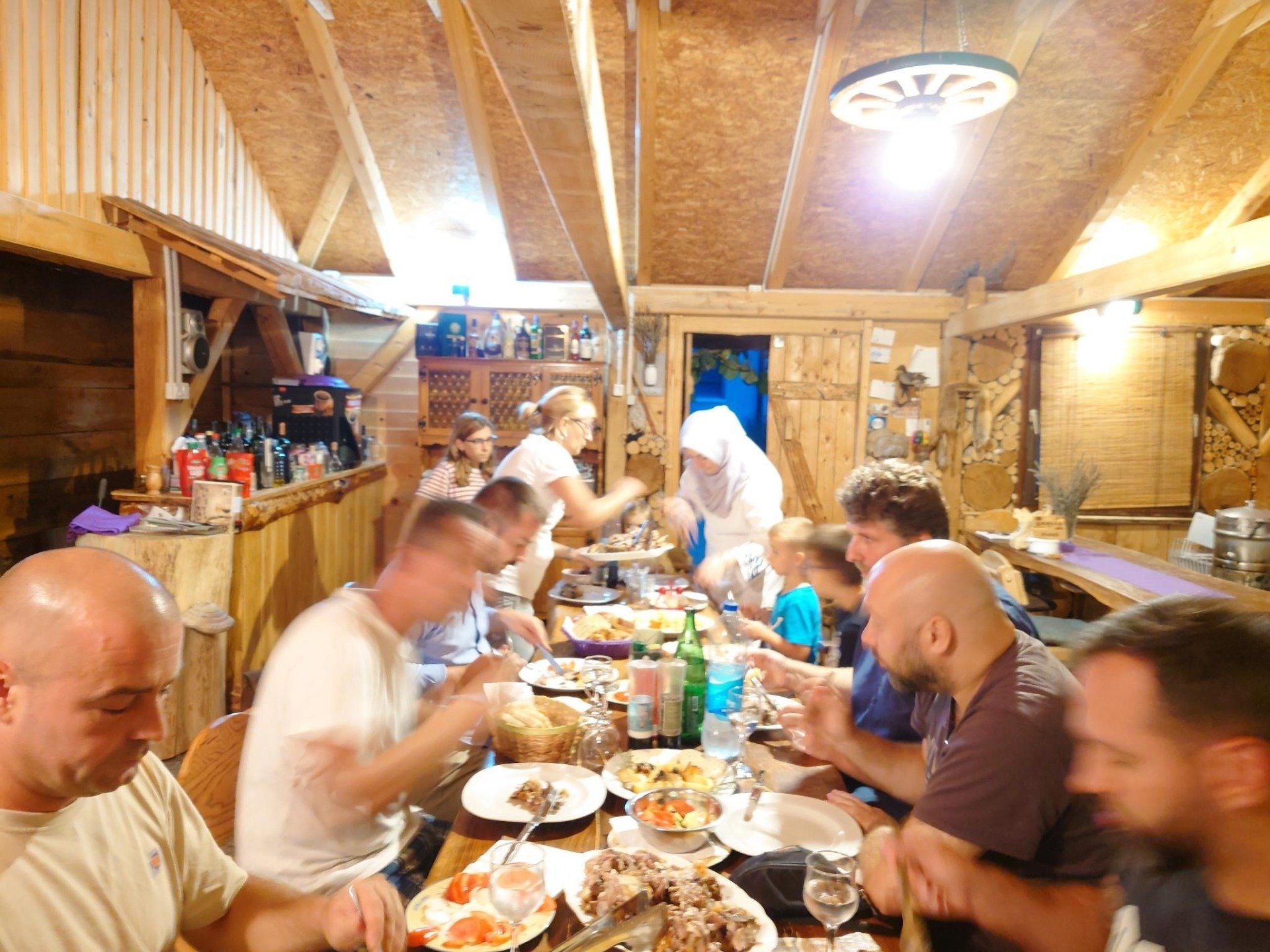 Eine Gruppe von Menschen sitzt an einem Tisch mit Tellern voller Essen