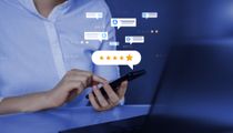 A person uses a smartphone against a blue background with digital five-star ratings and message bubble icons.