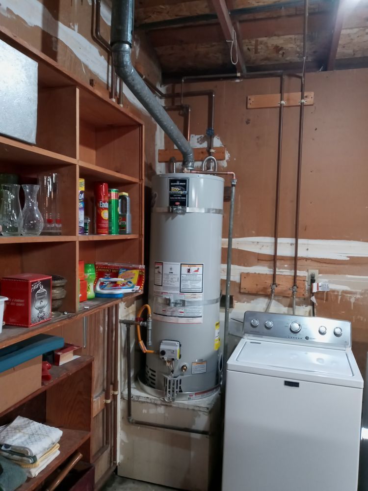 A laundry room with a water heater and a washer and dryer.