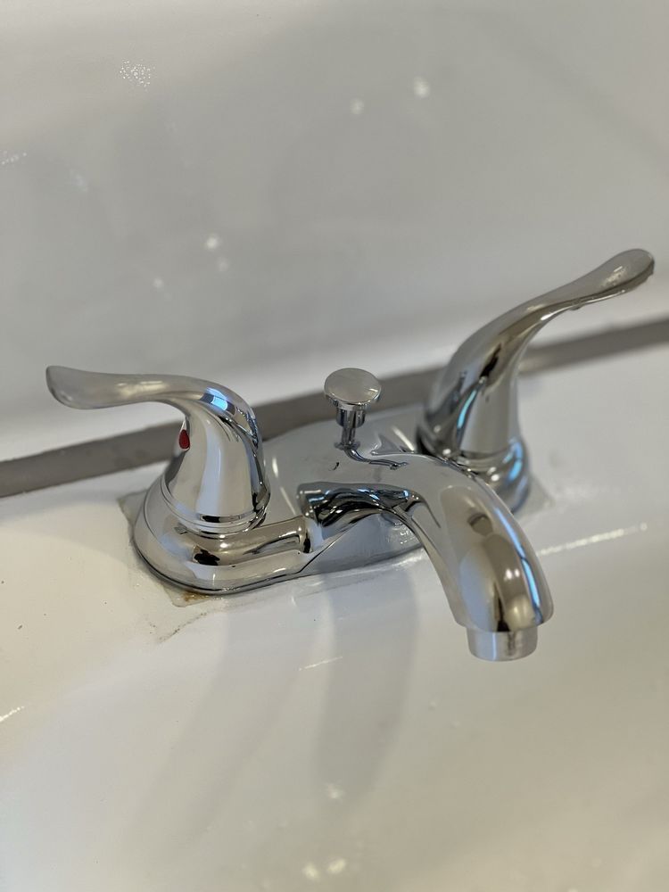 A close up of a bathroom sink with a chrome faucet.