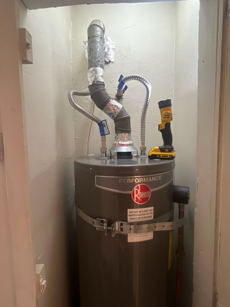 A water heater is sitting in a closet next to a door.