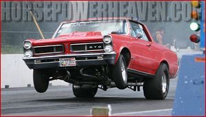 A red gto is driving down a race track