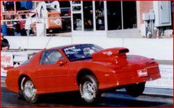 A red car is driving down a race track.