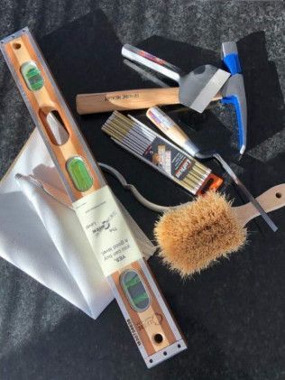 A level brush and other tools are on a table.