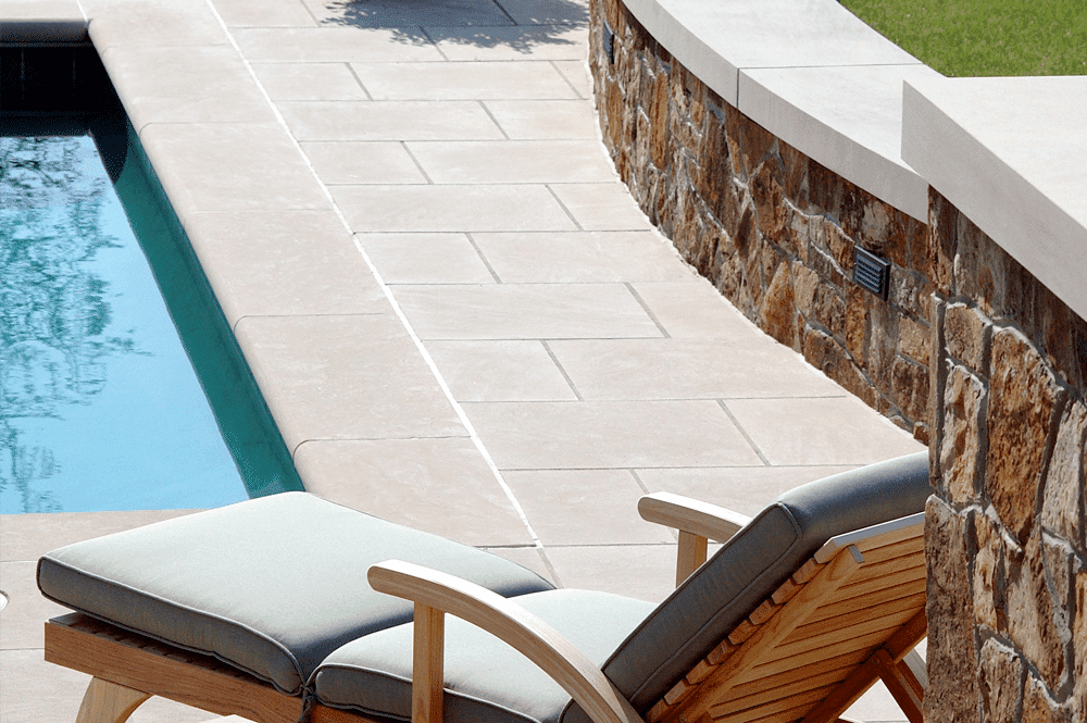 A large swimming pool with stairs and a hot tub in the middle.