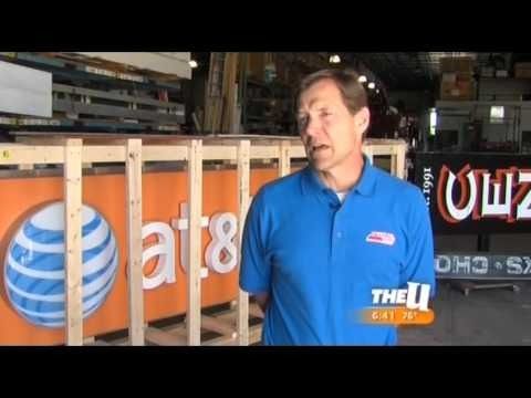 Man in blue shirt standing in front of an AT&T sign in a warehouse.