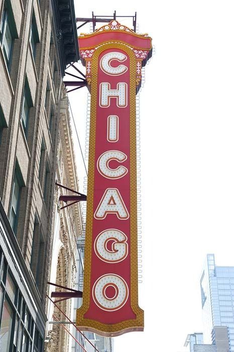 Chicago Theater marquee, tall red sign with white letters, hanging on a brick building.