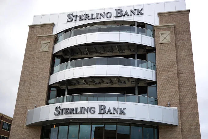 Sterling Bank building with light-colored brick and curved glass balconies. The bank name appears at the top and bottom.