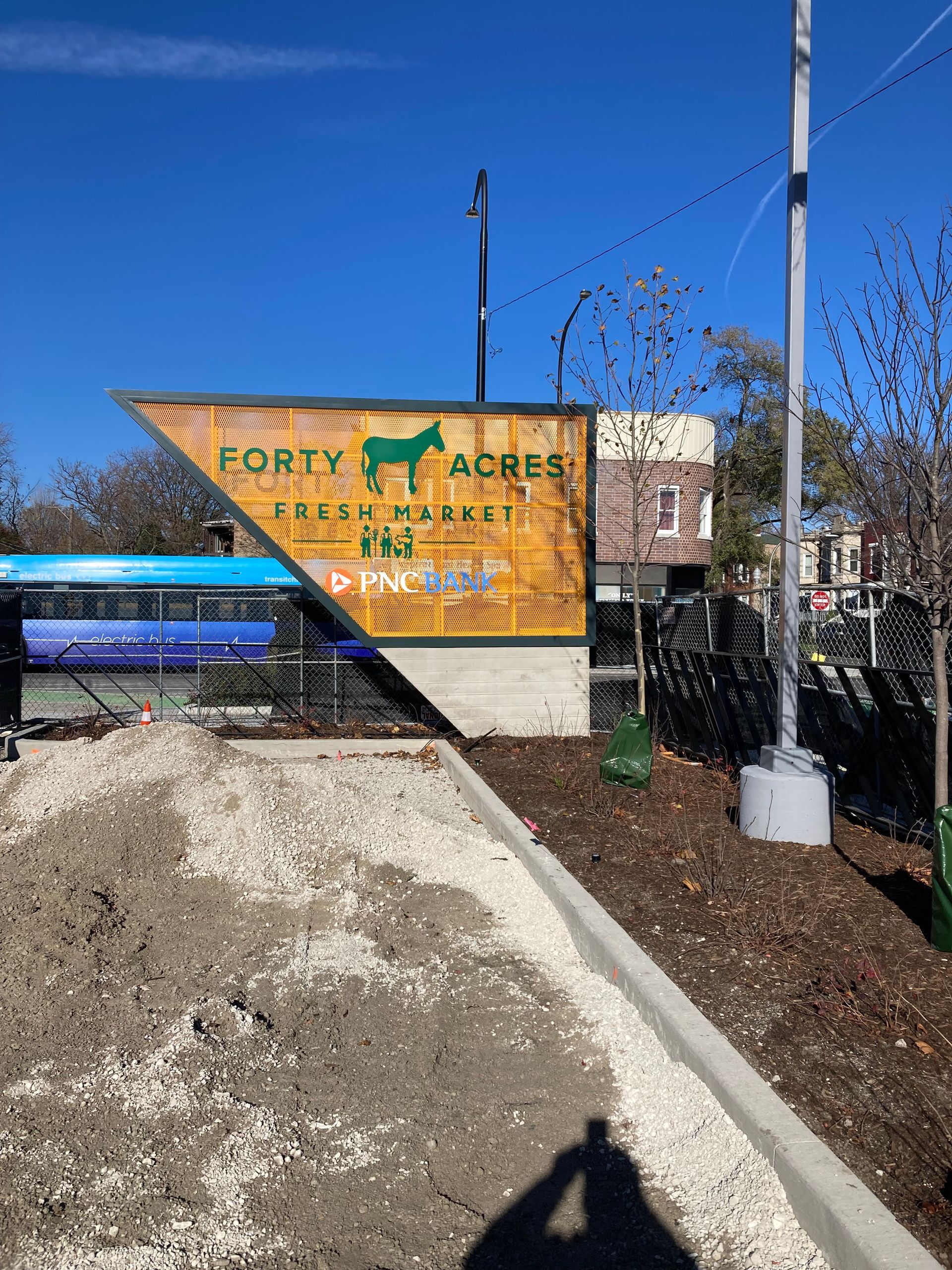 Sign for Forty Acres Park with horse logo; brown and green on a sunny day.