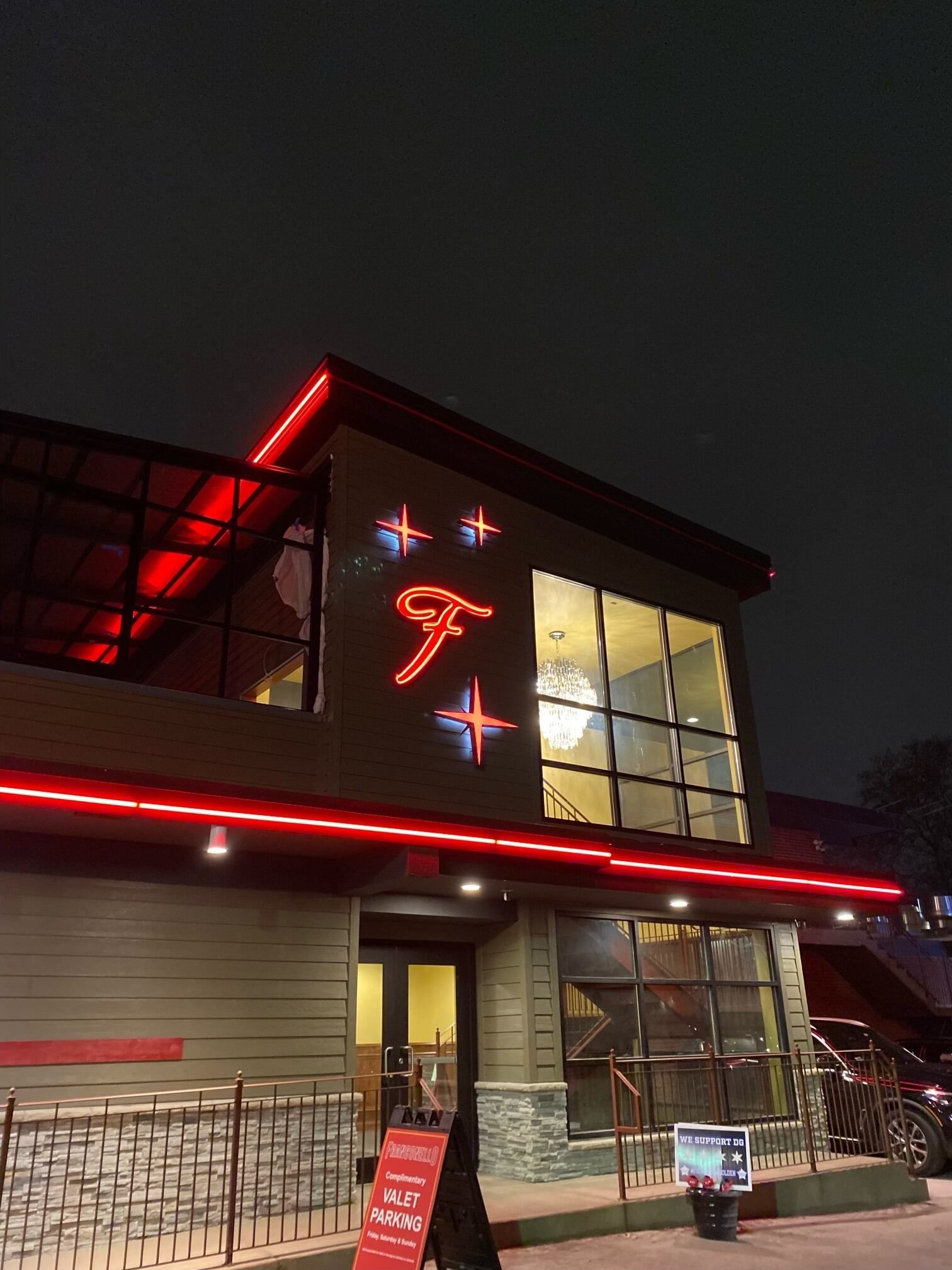 Restaurant exterior at night with red neon lights and a large