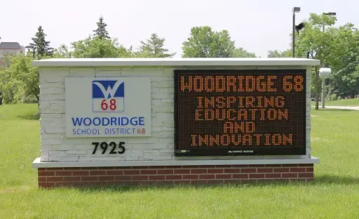 Sign for Woodridge School District 68, with logo, address, and electronic message board.