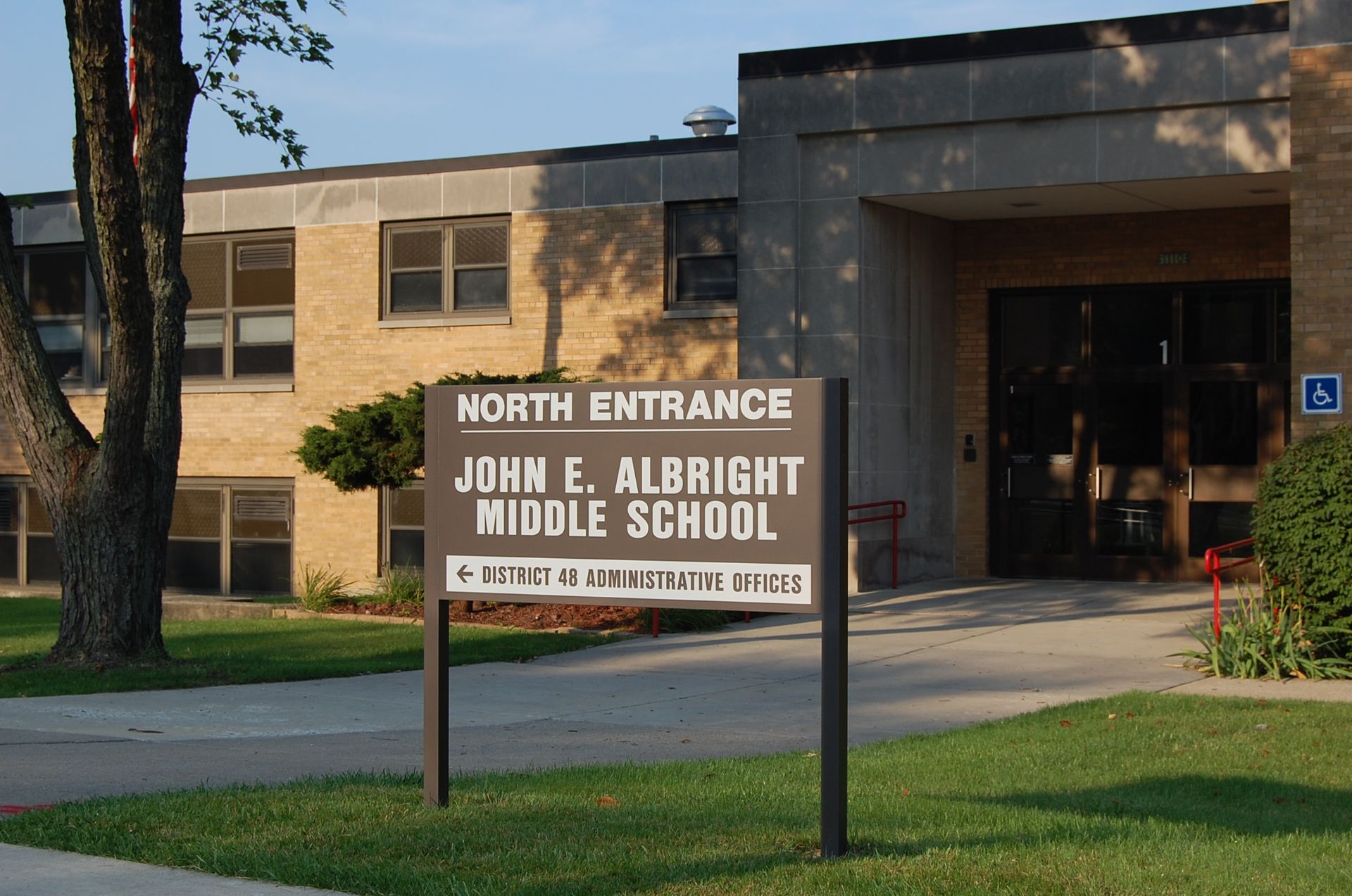 Sign for John E. Albright Middle School in front of the school building.