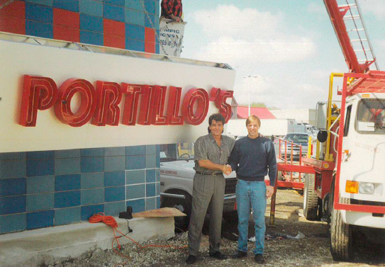 Two men shake hands in front of a