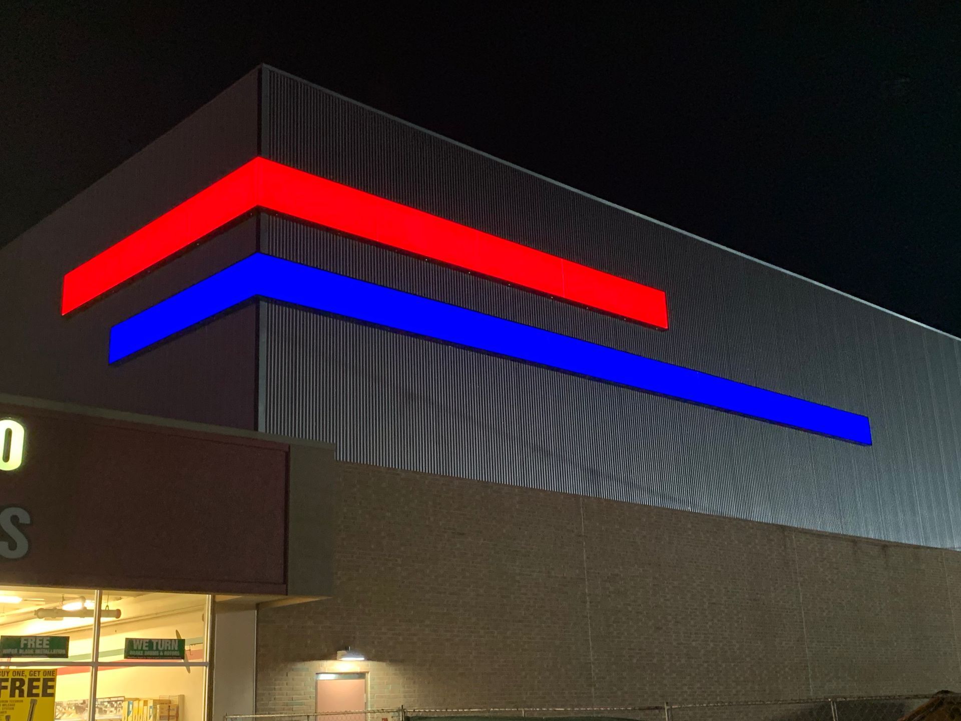 Red and blue neon sign on a building at night.