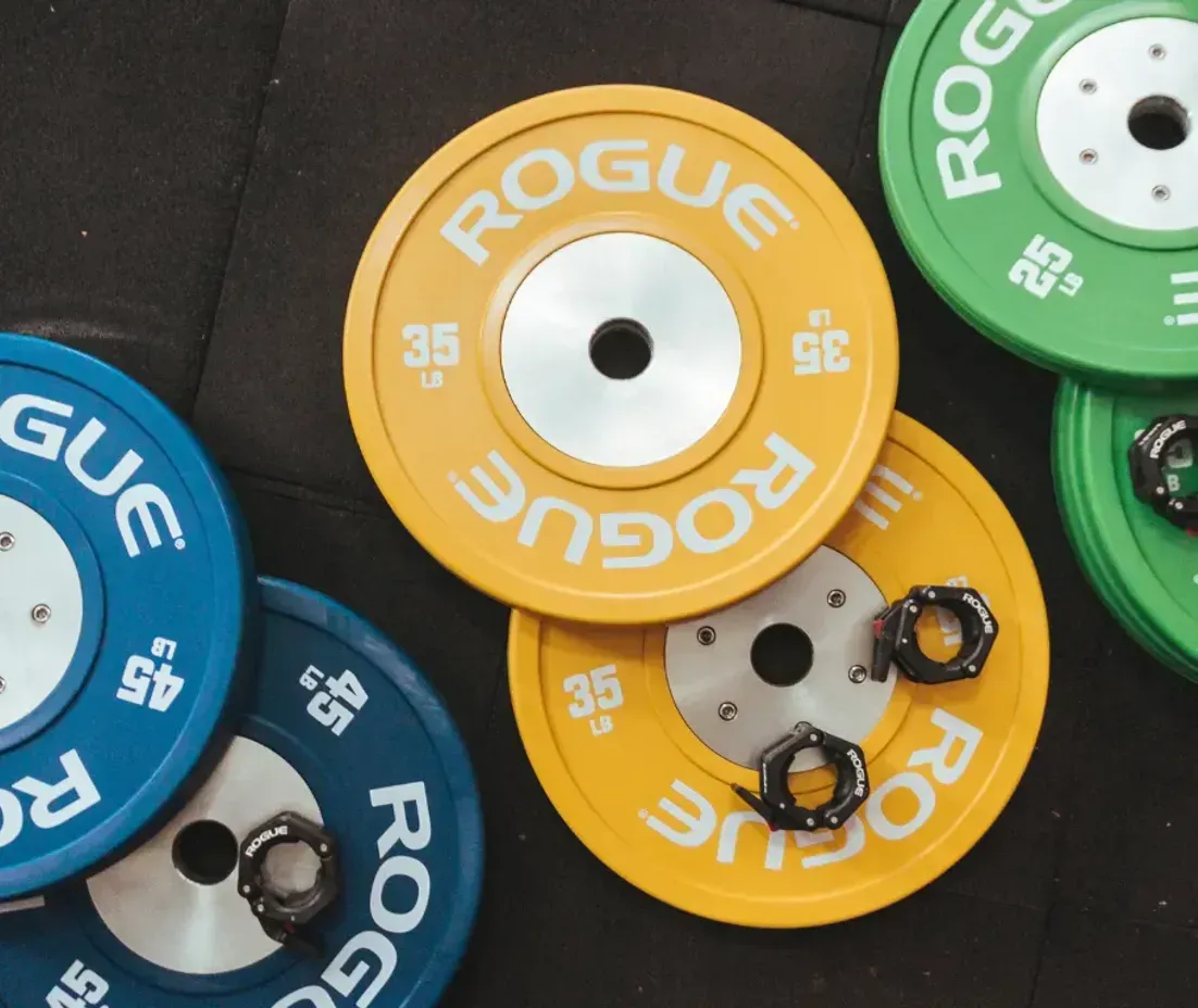 A bunch of rogue weight plates are stacked on top of each other.