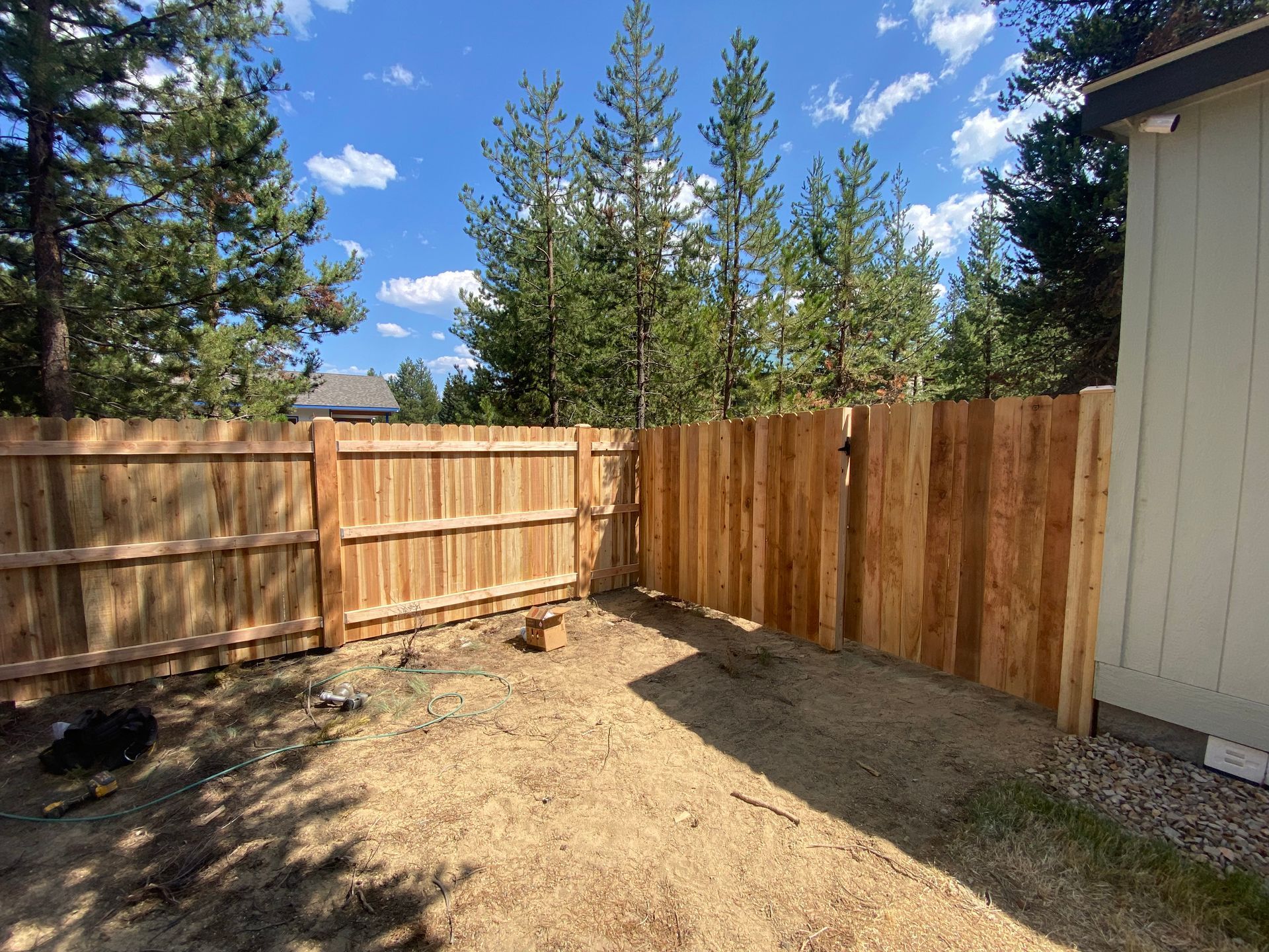 There is a wooden fence in the backyard of a house.