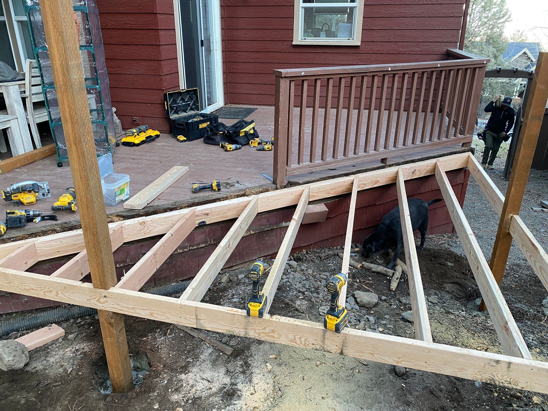 A wooden deck is being built on the side of a house.