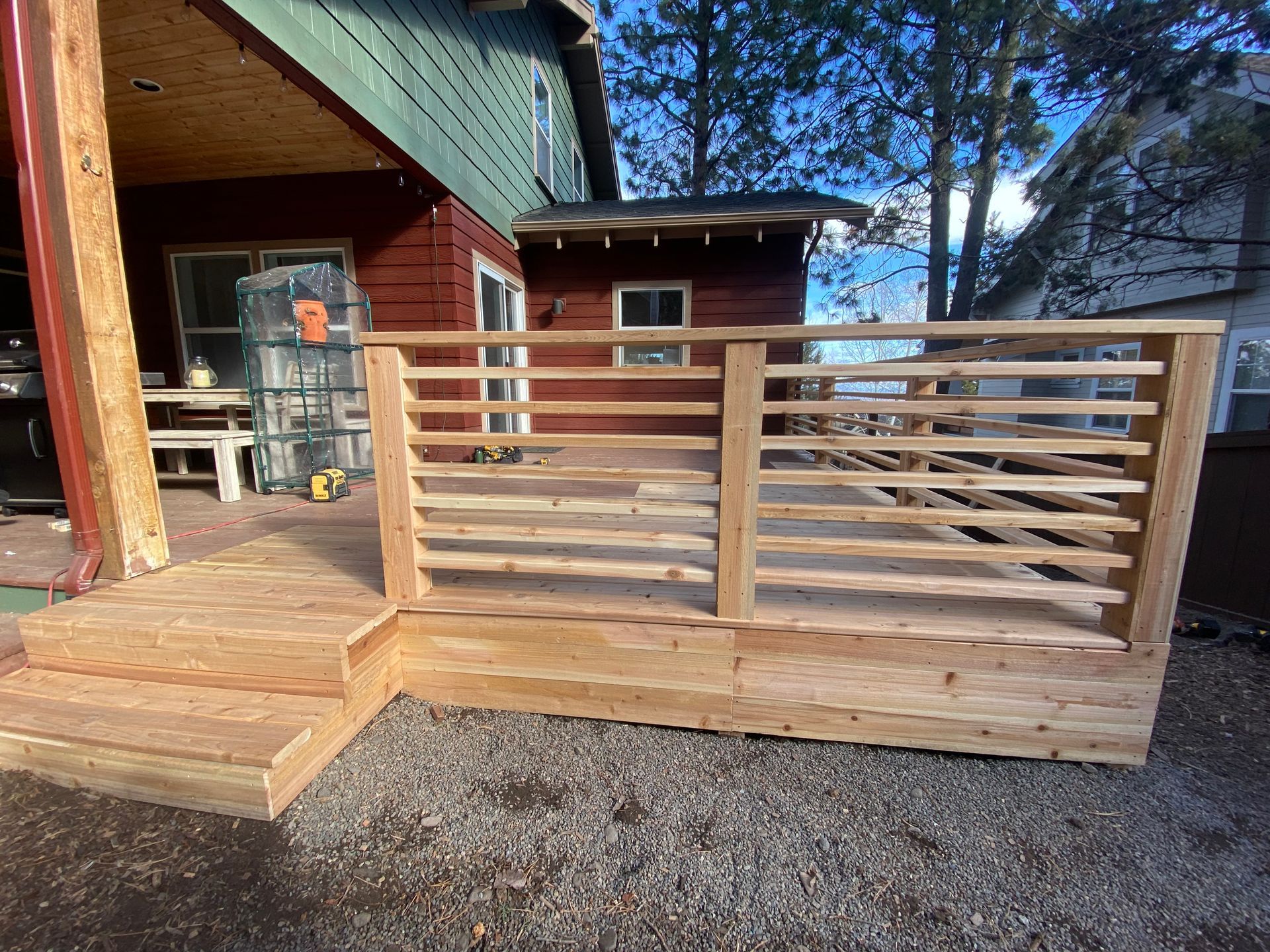 A wooden deck is being built in front of a house.