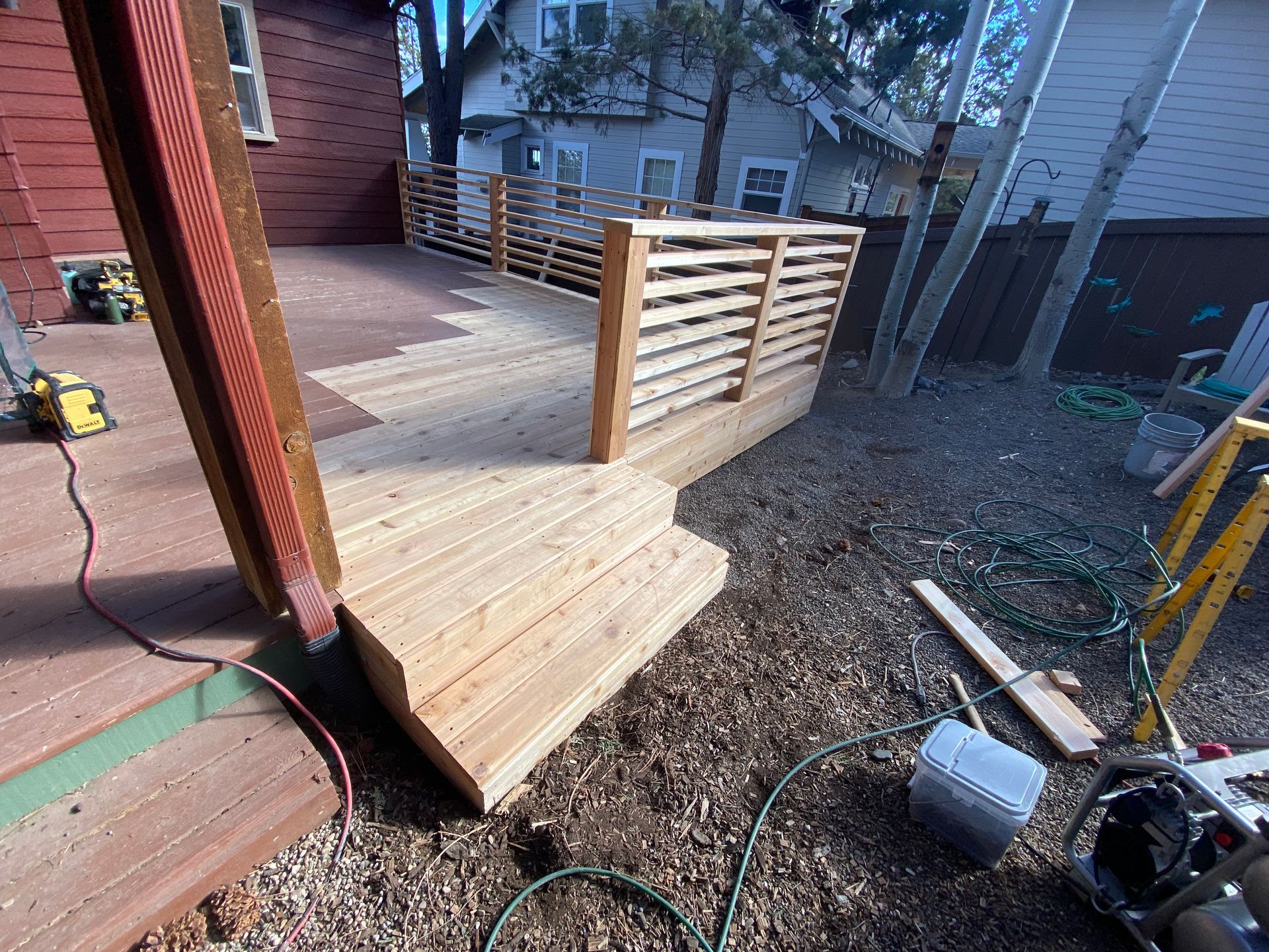 A wooden deck is being built in the backyard of a house.