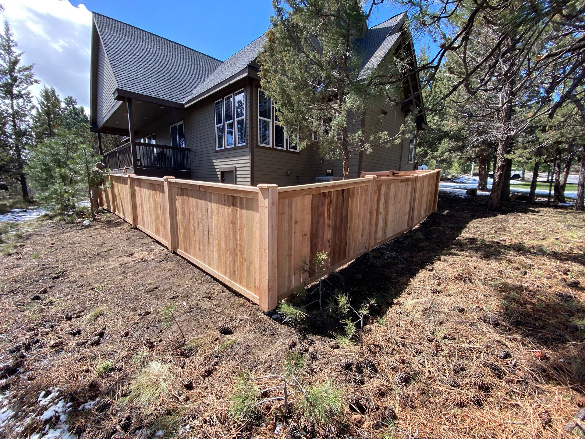 A house with a wooden fence in front of it.