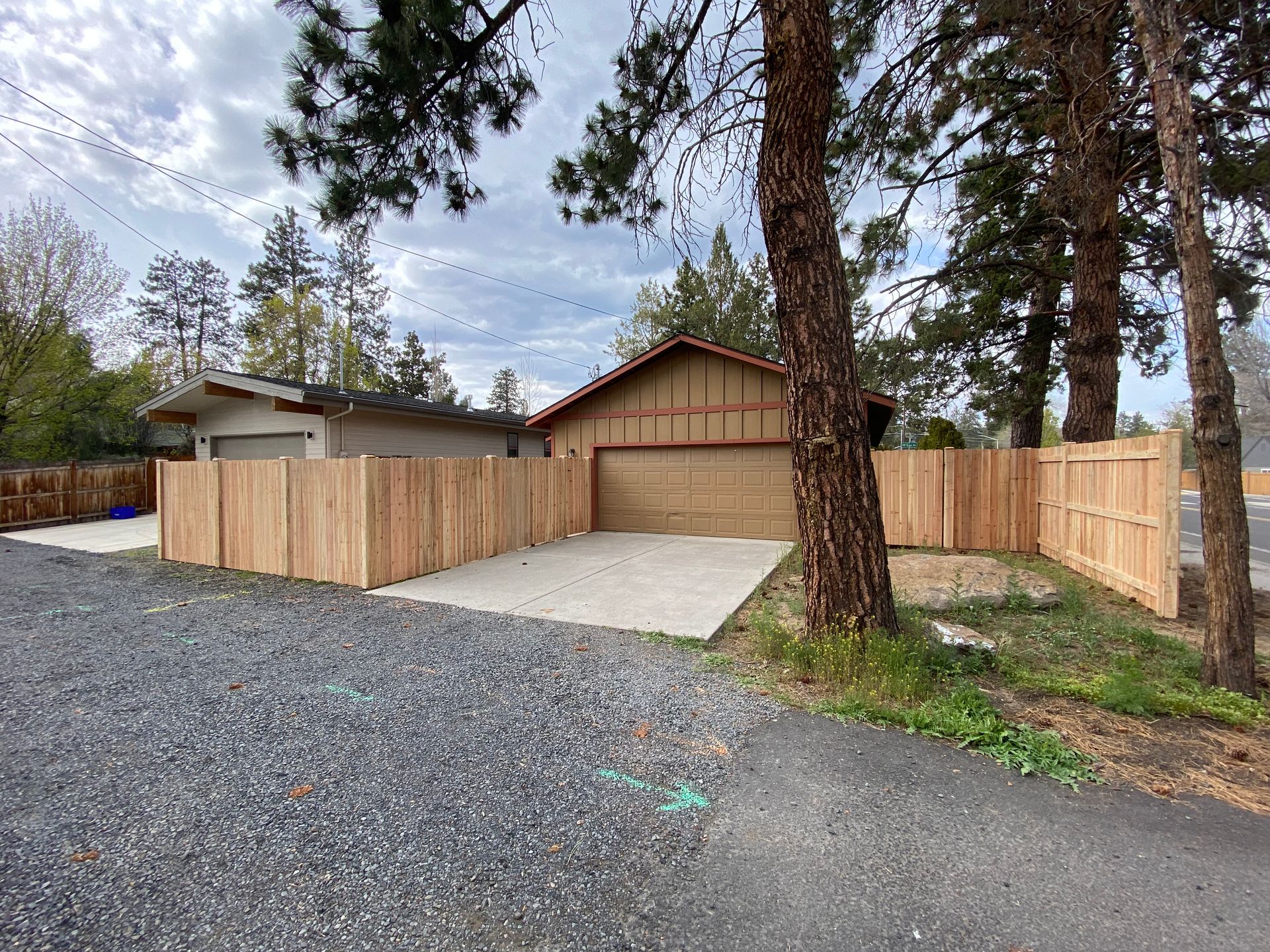 A house with a garage and a wooden fence around it.