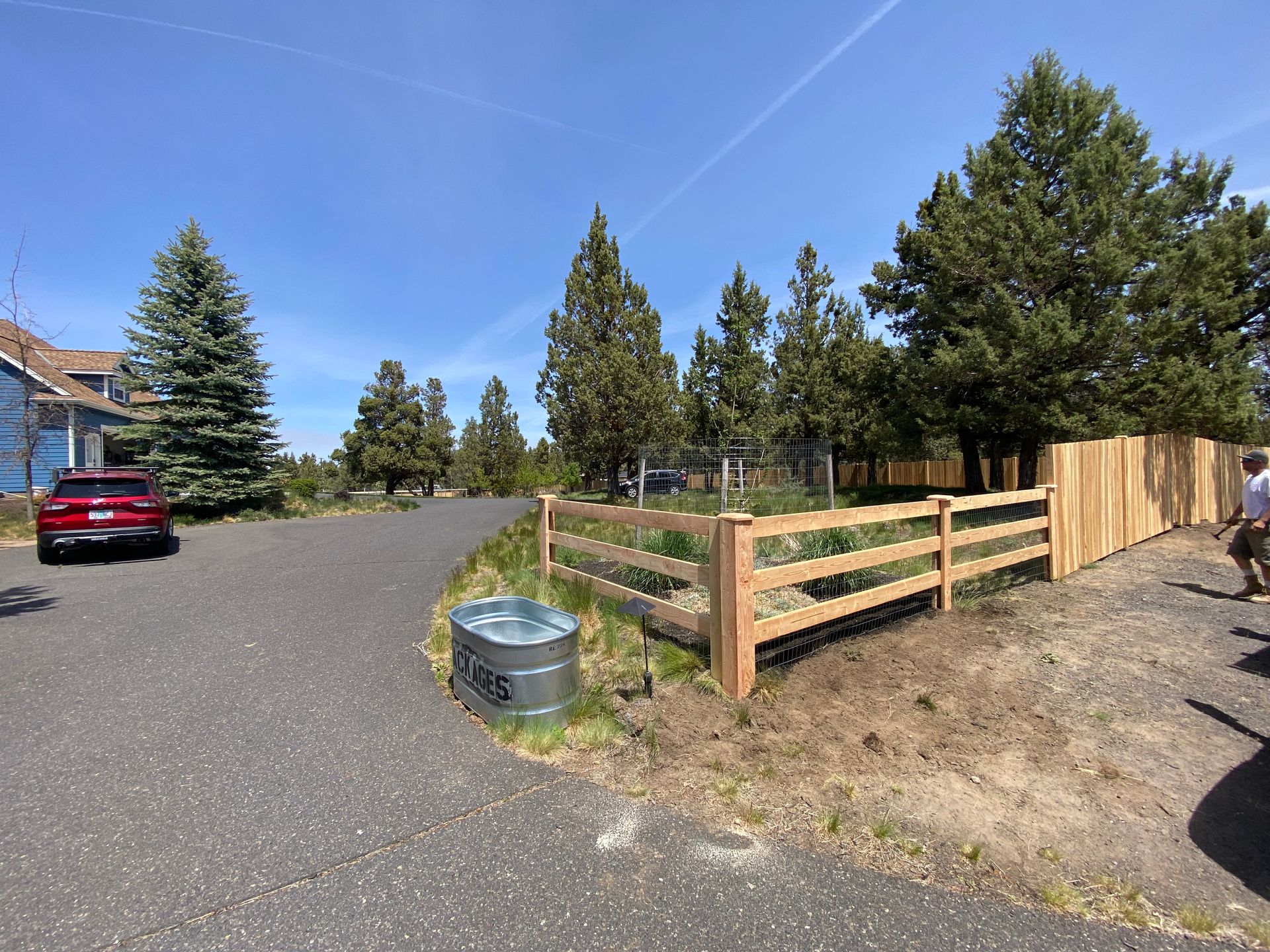 A wooden fence is being built on the side of a road.