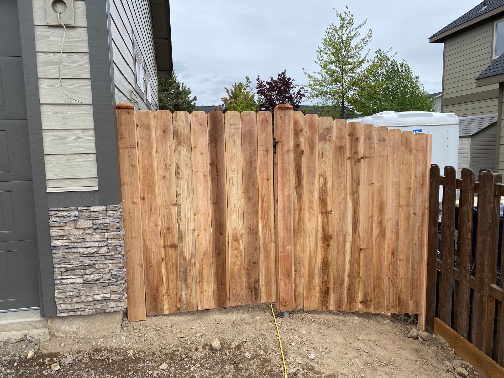 A wooden fence is being built in front of a house.