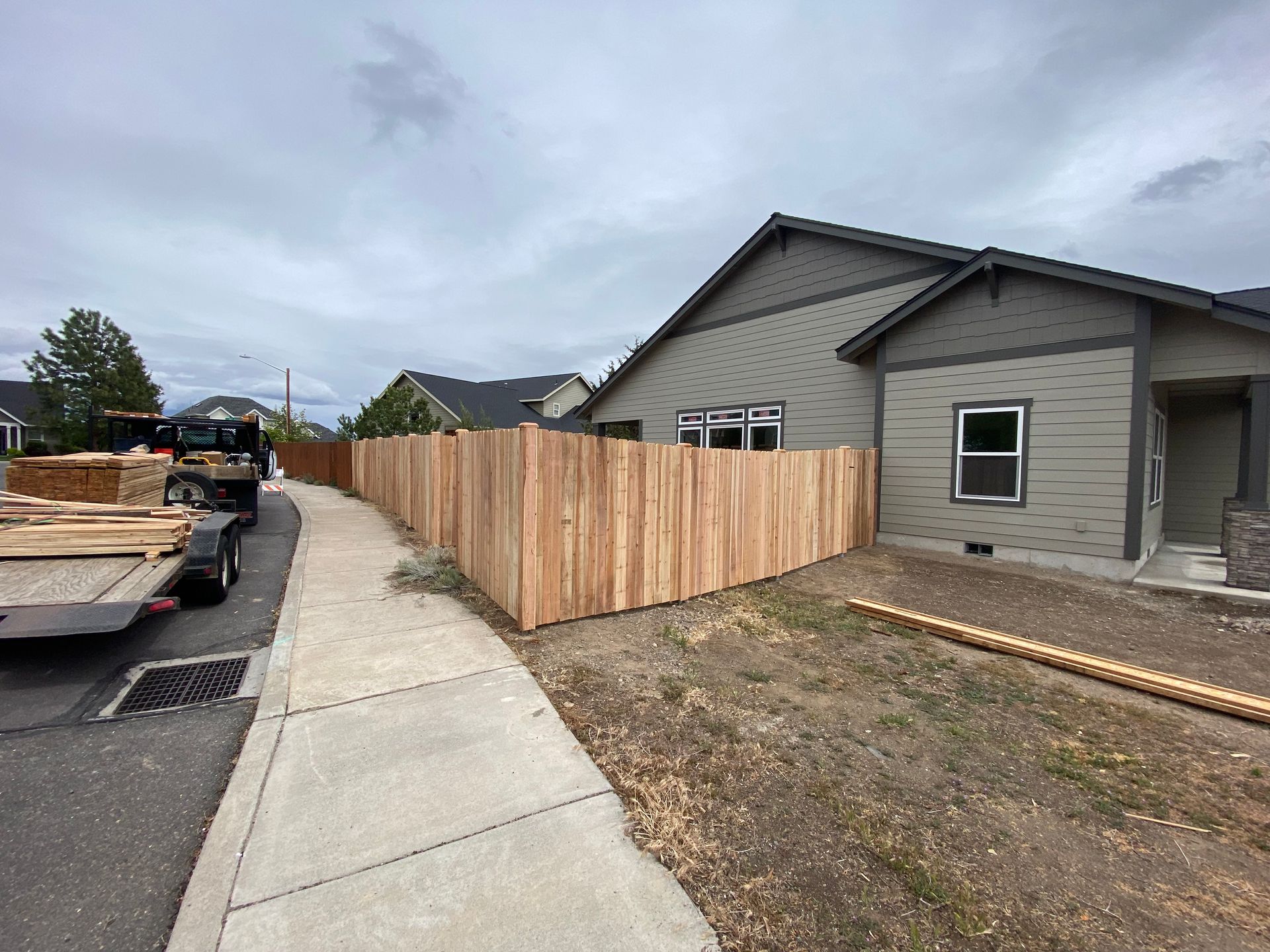 A wooden fence is being built in front of a house.