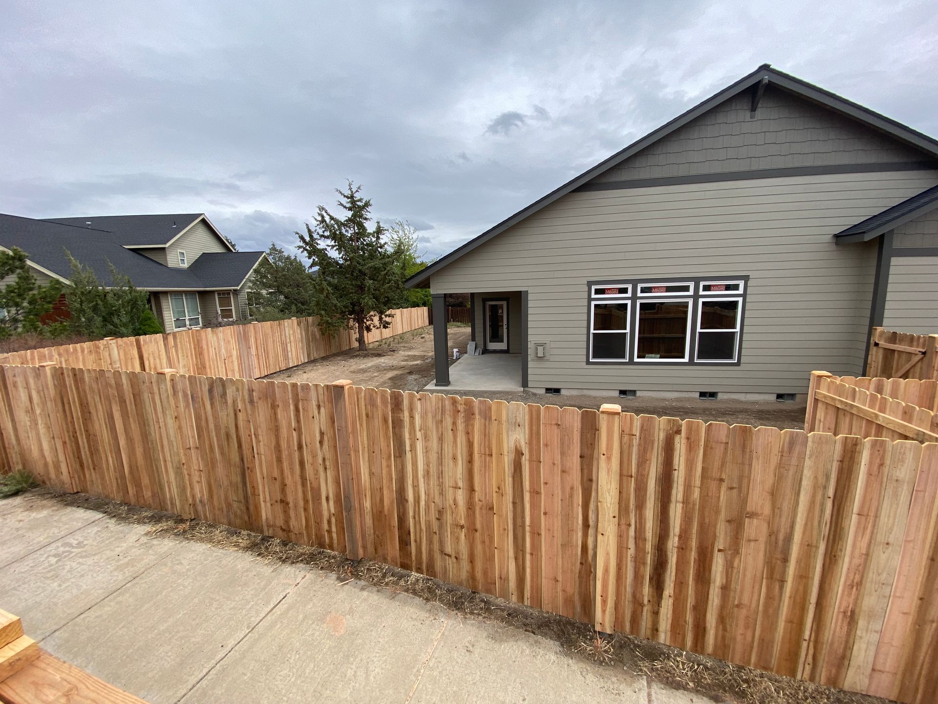 A house with a wooden fence in front of it.