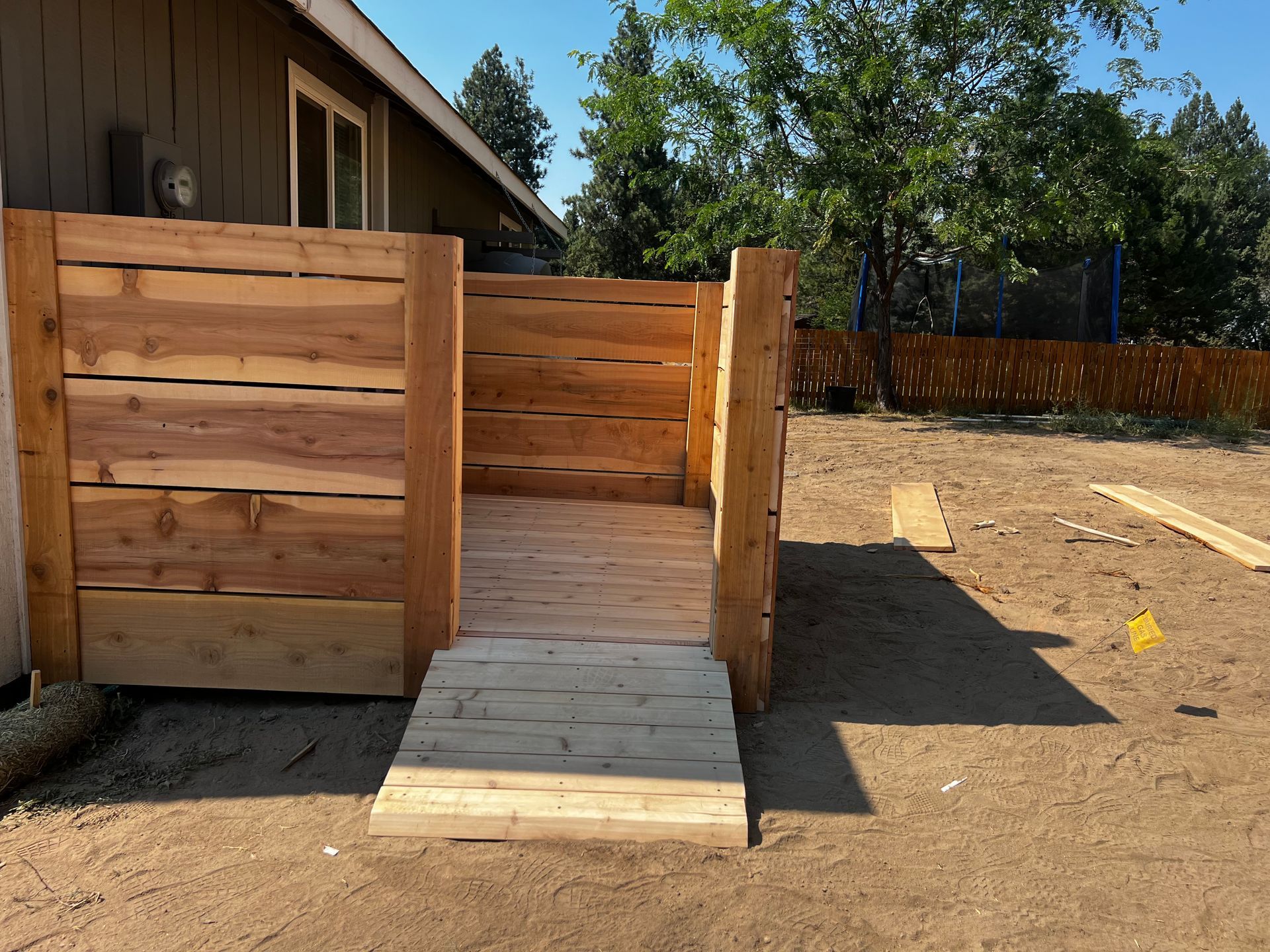 A wooden fence with a ramp in front of a house.