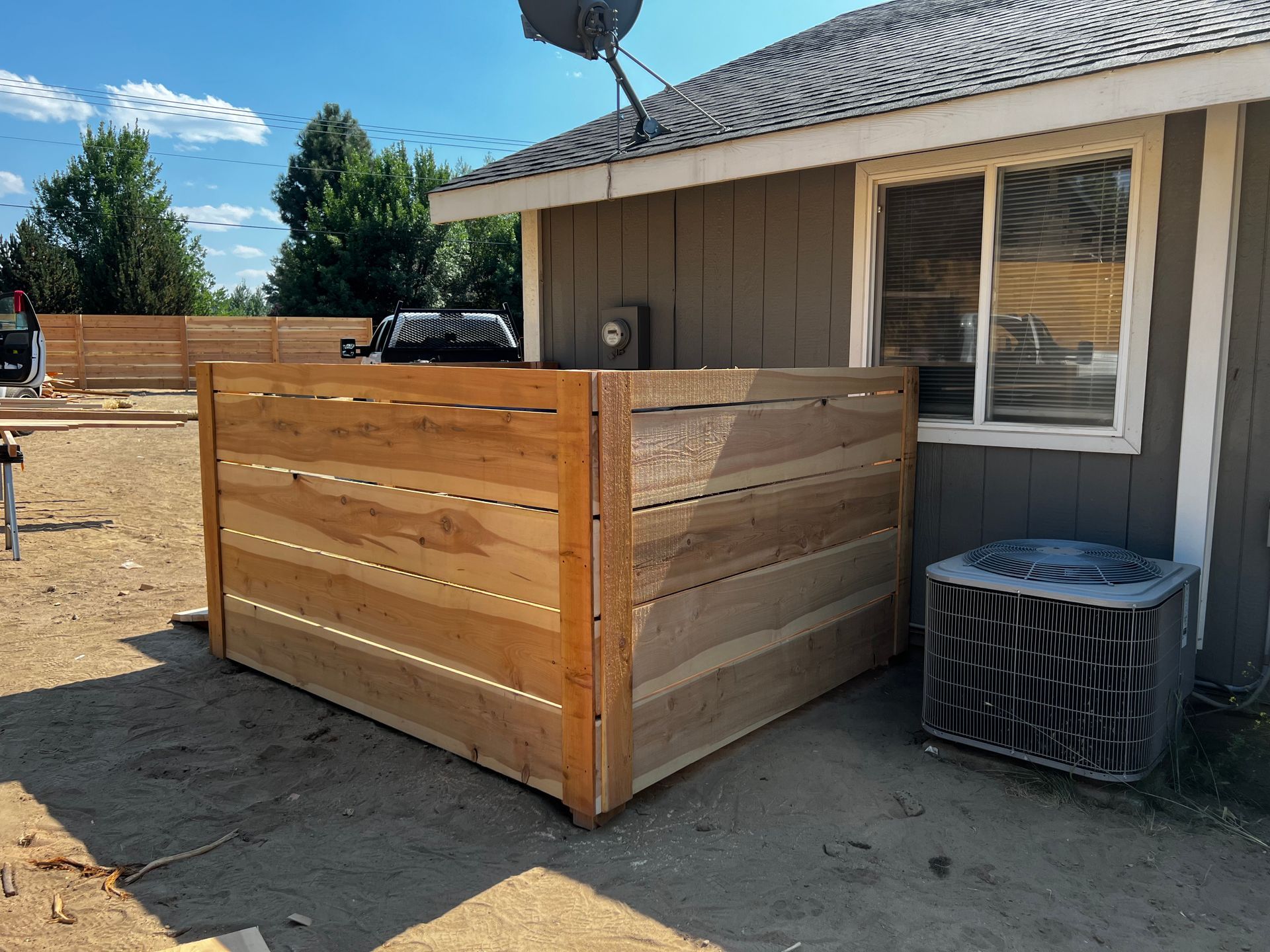 A wooden fence is being built in front of a house.