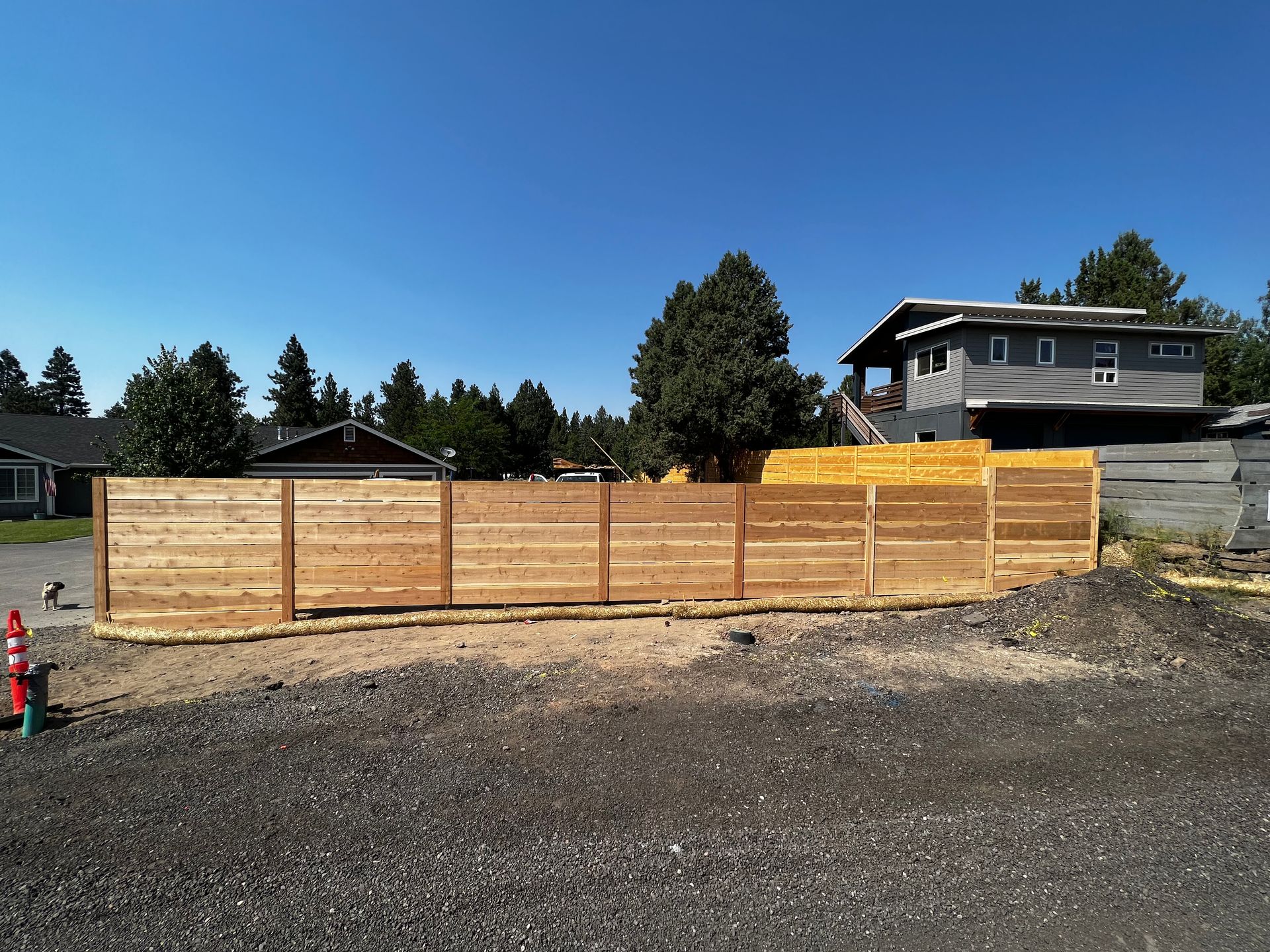 A wooden fence with a house in the background