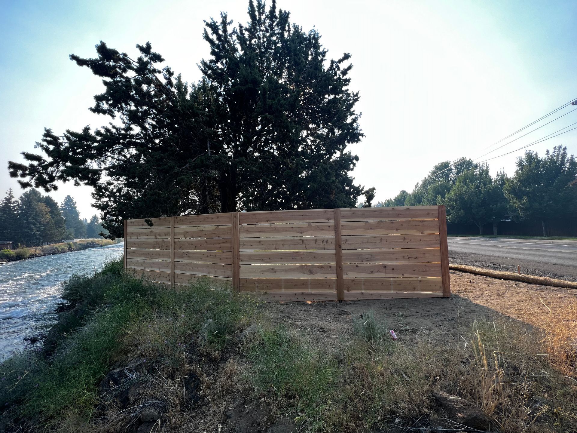 A wooden fence with a tree in the background