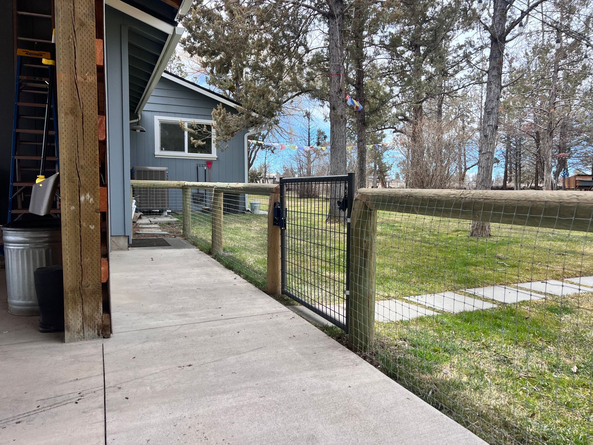 A walkway leading to a house with a fence and a gate