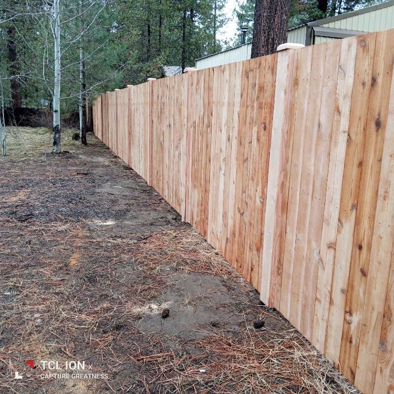 A wooden fence is sitting in the middle of a dirt field.