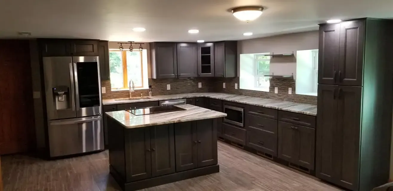 Newly renovated kitchen with dark cabinets, stainless steel appliances, and a central island.