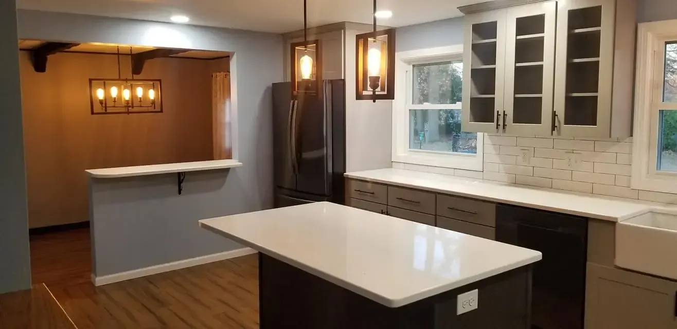 Kitchen renovation with an island, cabinets, and two pendant lights over the island.