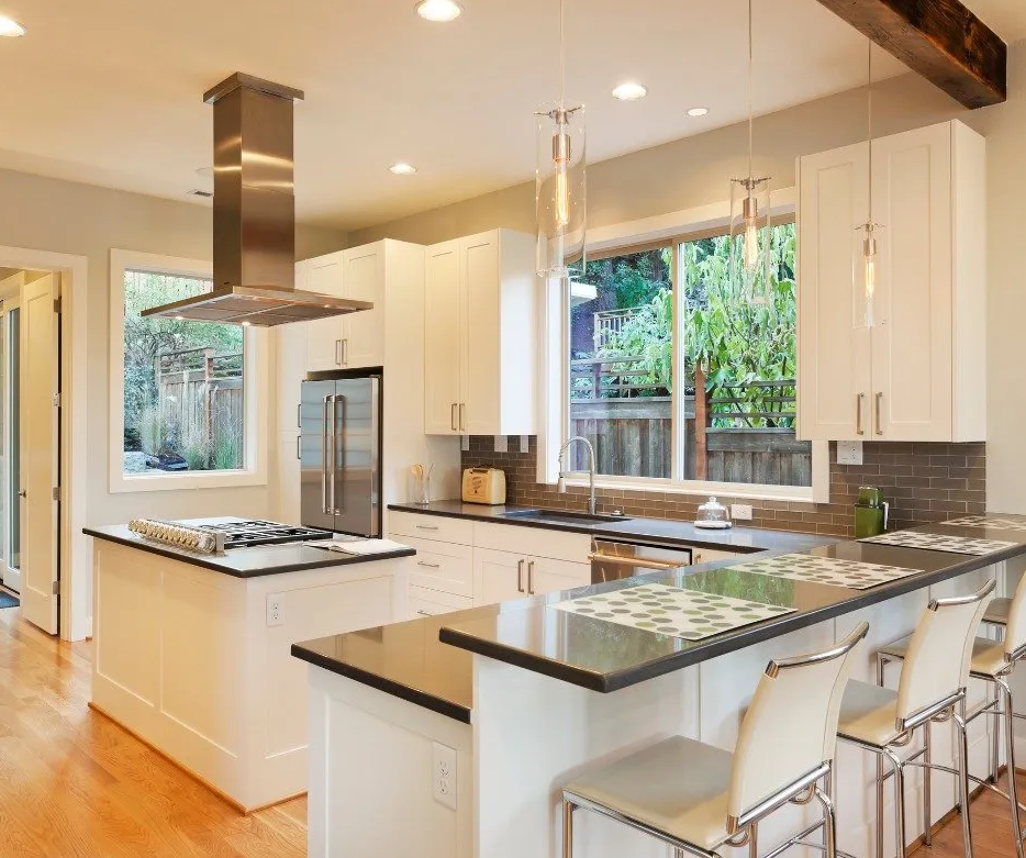 Image of an indoor kitchen renovation with white cabinets and gray countertops.
